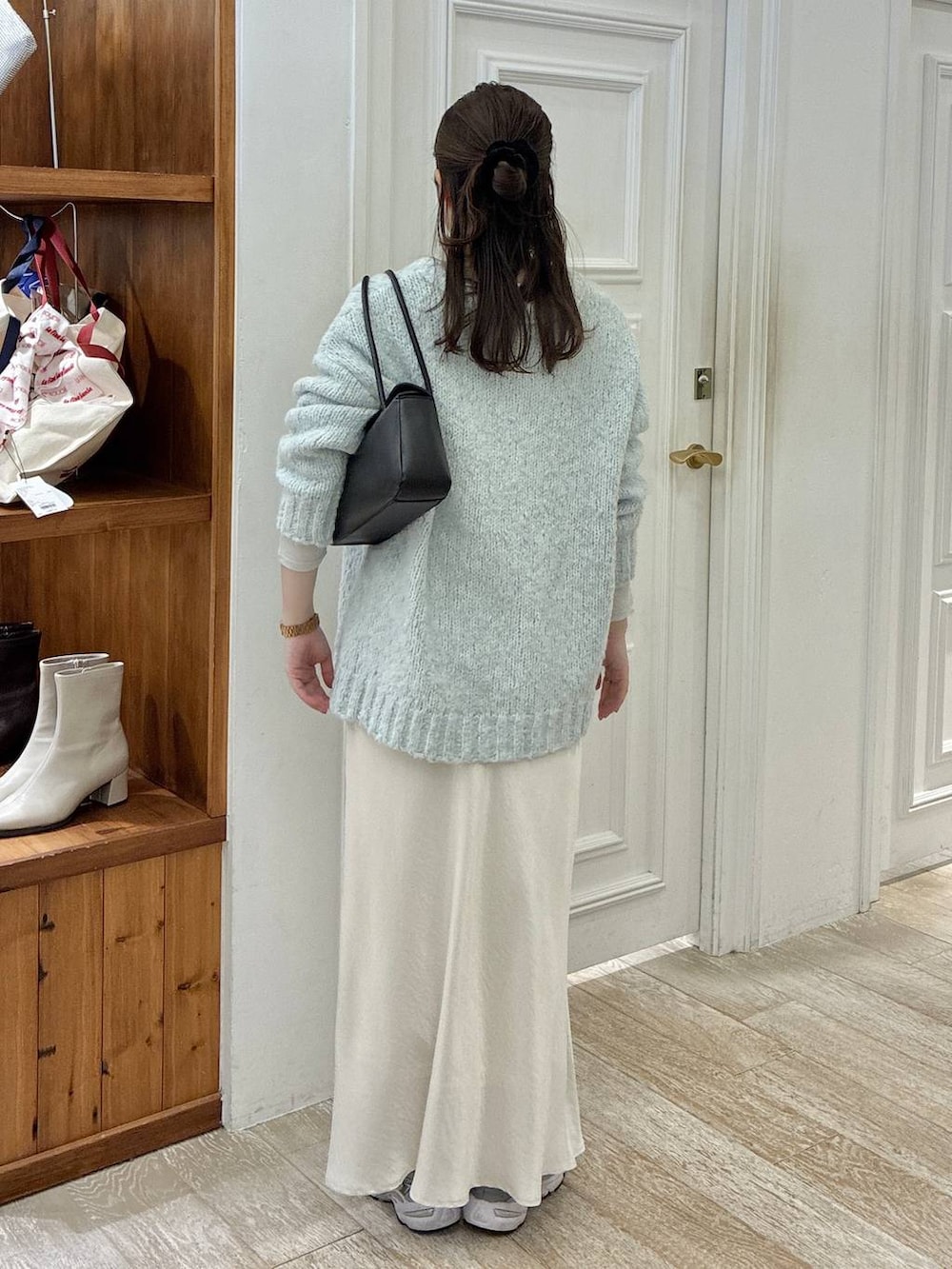 ホワイト系のスカート、グリーン系のニット/セーター、ブラック系のショルダーバッグを着用したレディースの冬コーディネートの3枚目の写真