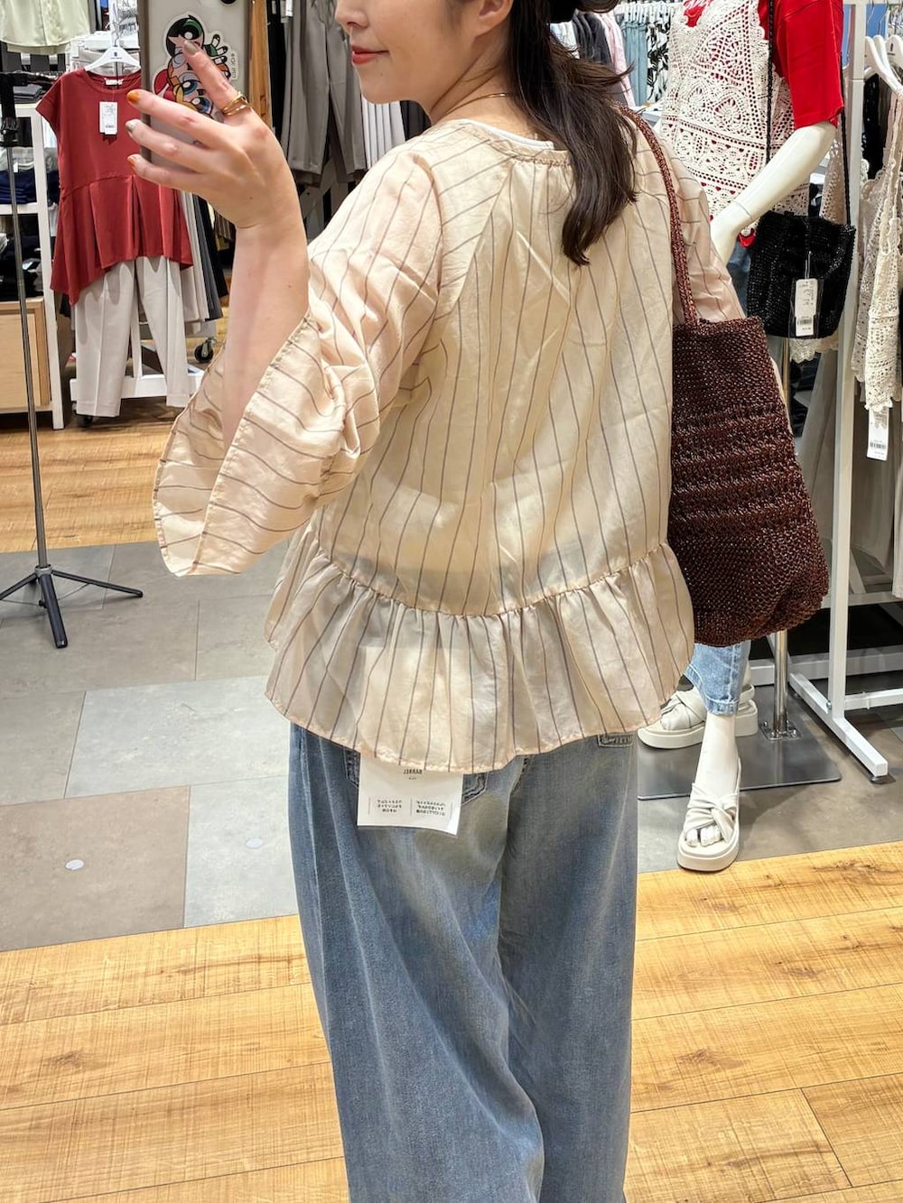ブルー系のデニムパンツ、ホワイト系のタンクトップ、ブラウン系のトートバッグを着用したレディースの夏コーディネートの6枚目の写真