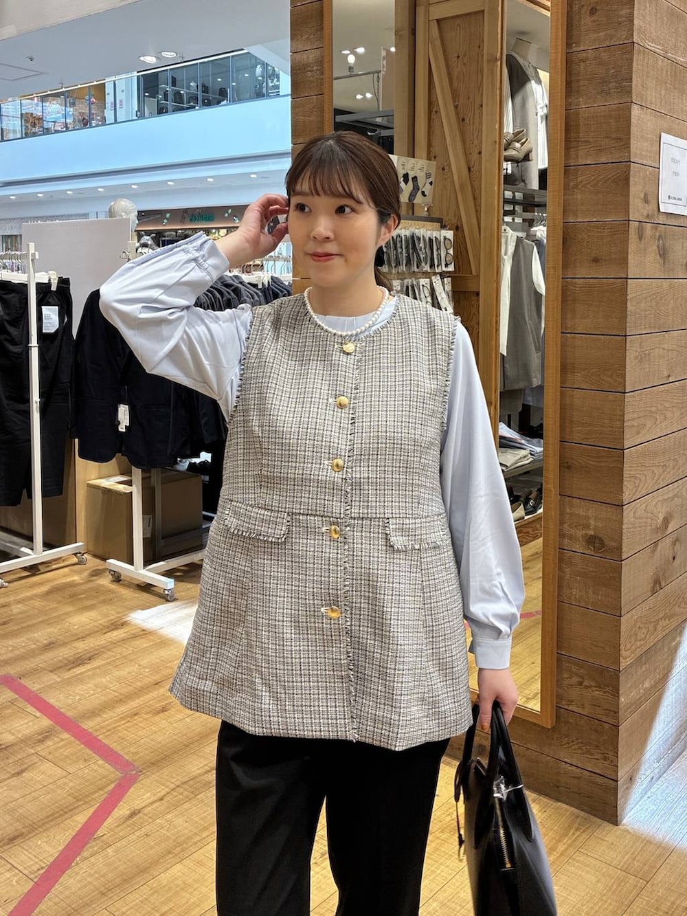 ブラック系のショルダーバッグ、ブラック系のパンプス、ブラック系のスラックスを着用したレディースの春コーディネートの4枚目の写真