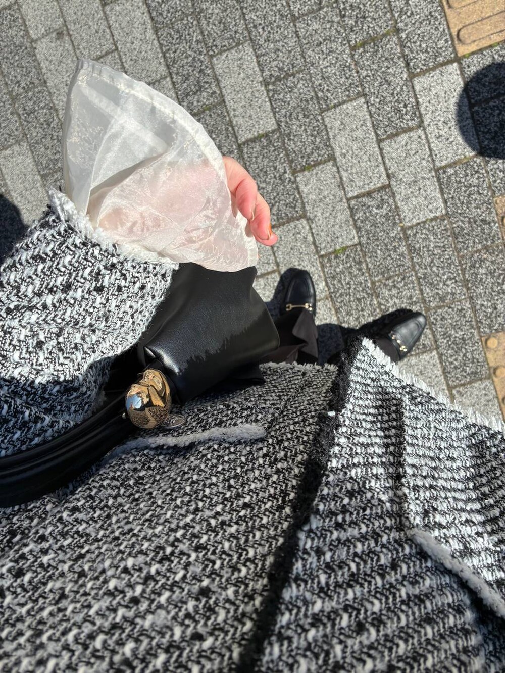 ブラック系のローファー、ブラック系のショルダーバッグ、ブラック系のノーカラージャケットを着用したレディースの春コーディネートの2枚目の写真