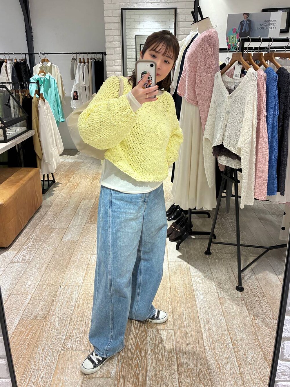 ブルー系のデニムパンツ、イエロー系のニット/セーター、ホワイト系のTシャツ/カットソーを着用したレディースの冬コーディネートの3枚目の写真