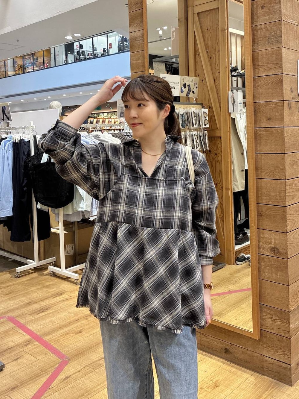 ブルー系のデニムパンツ、ベージュ系のショルダーバッグ、ブラック系のシャツ/ブラウスを着用したレディースの春コーディネートの4枚目の写真