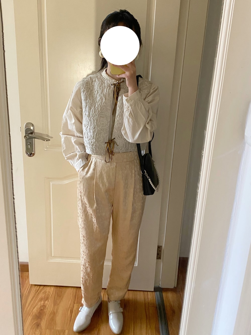 ホワイト系のベスト、ベージュ系のドレスシューズ、ベージュ系のシャツ/ブラウスを着用したレディースの春コーディネートの2枚目の写真