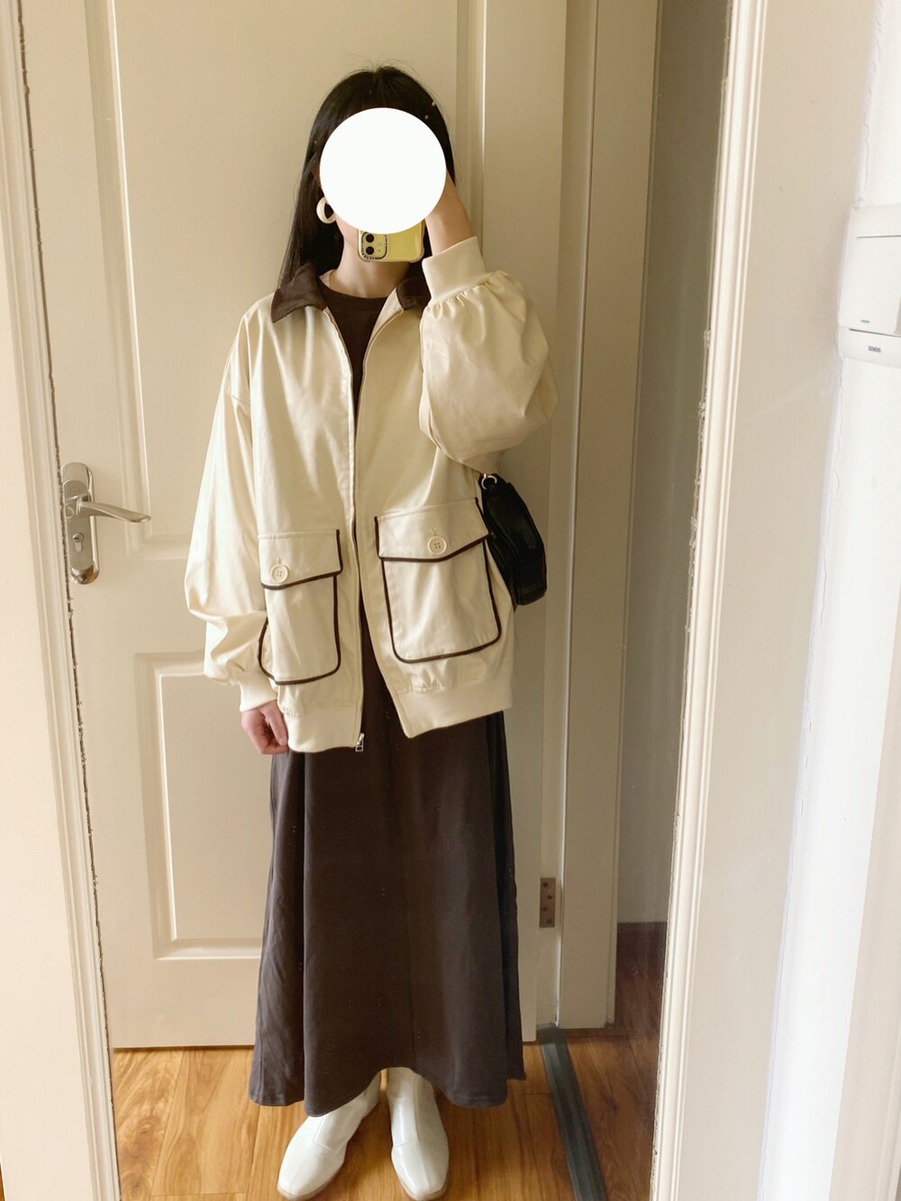 ホワイト系のブルゾン、グレー系のワンピースを着用したレディースの春コーディネートの2枚目の写真