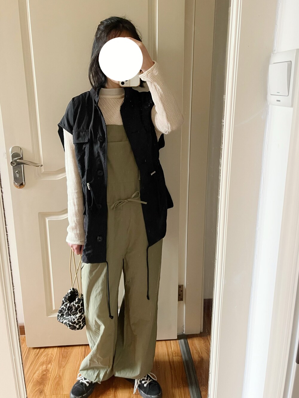 その他のハンドバッグ、グリーン系のサロペット/オーバーオール、ブラック系のベストを着用したレディースの春コーディネートの2枚目の写真