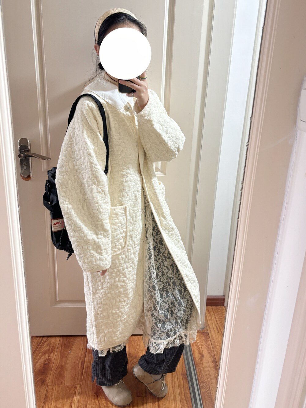 ホワイト系のワンピース、ホワイト系のノーカラーコート、ブラック系のショルダーバッグを着用したレディースの冬コーディネートの2枚目の写真