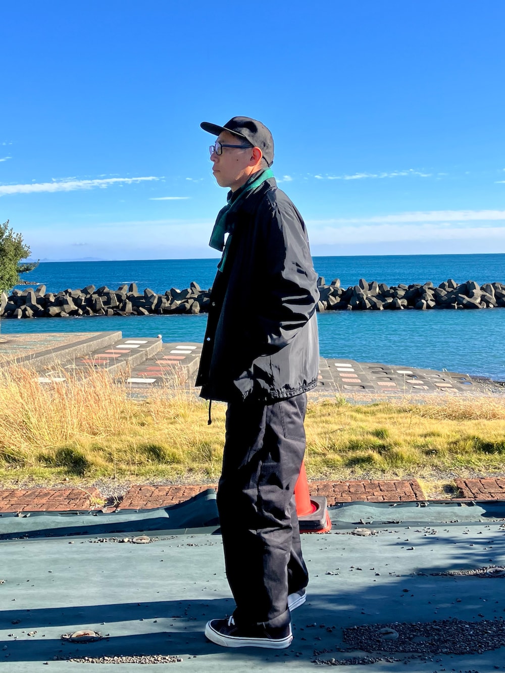 ブラック系のスウェット、ブラック系のブルゾン、ブルー系のパンツを着用したメンズの秋コーディネートの2枚目の写真