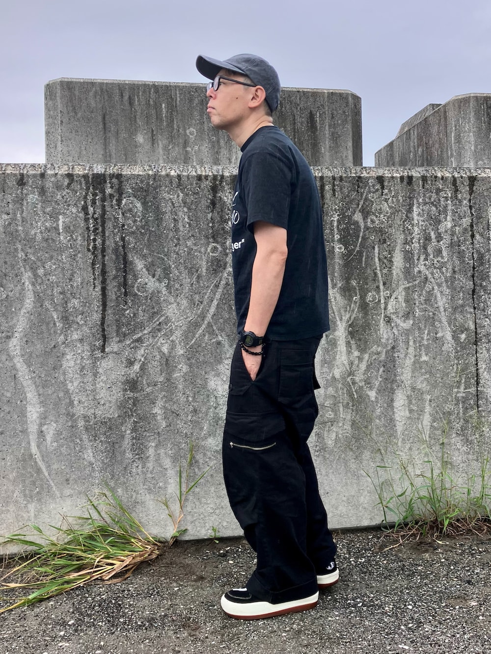 ブラック系のスニーカー、ブラック系のTシャツ/カットソー、ブラック系のその他パンツを着用したメンズの秋コーディネートの2枚目の写真