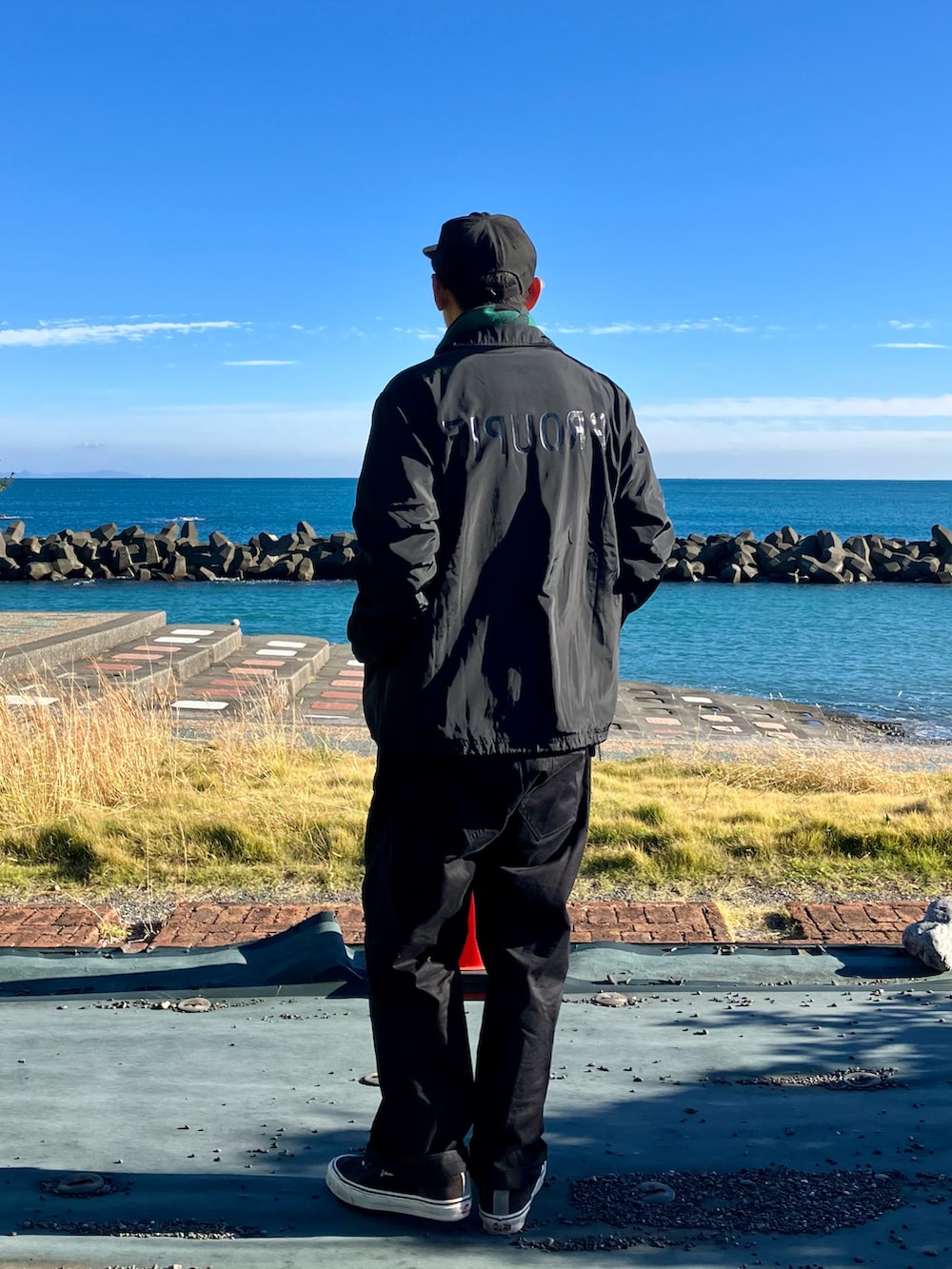 ブラック系のスウェット、ブラック系のブルゾン、ブルー系のパンツを着用したメンズの秋コーディネートの3枚目の写真