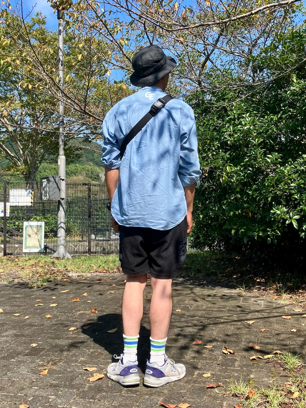 ブルー系のシャツ/ブラウス、ブラック系のボディバッグ/ウエストポーチ、ブラック系のその他パンツを着用したメンズの秋コーディネートの2枚目の写真