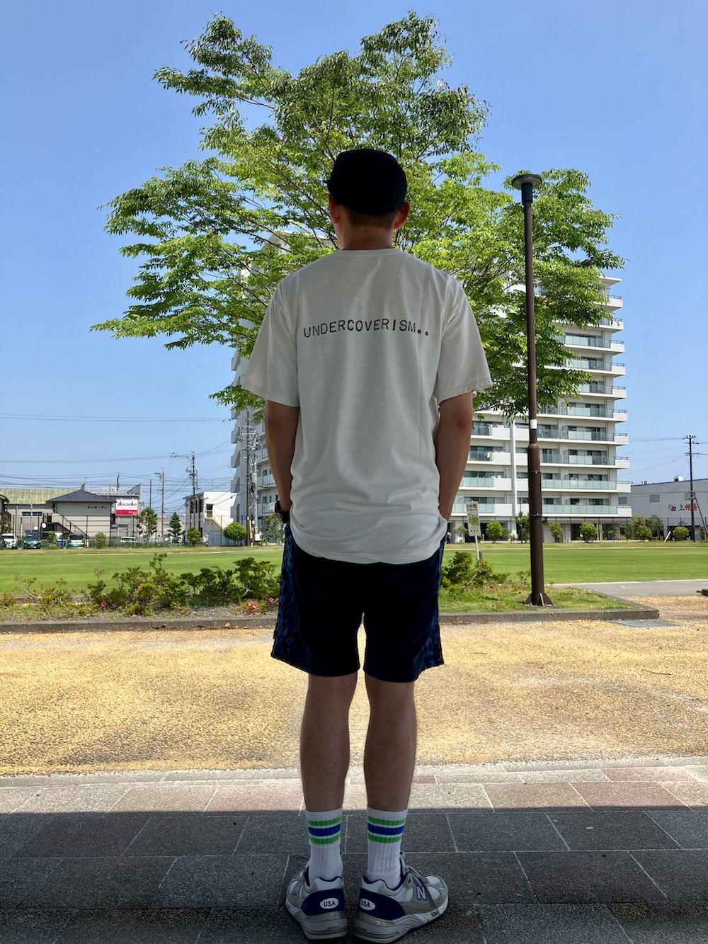 ホワイト系のTシャツ/カットソー、ブルー系のその他パンツ、ホワイト系のスニーカーを着用したメンズの春コーディネートの2枚目の写真