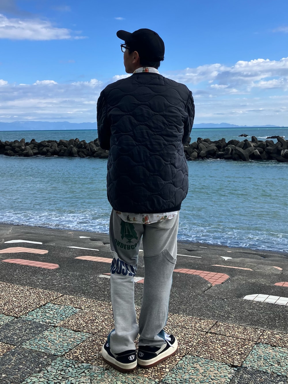 ブラック系のスニーカー、ホワイト系のシャツ/ブラウス、ブラック系のミリタリージャケットを着用したメンズの冬コーディネートの2枚目の写真