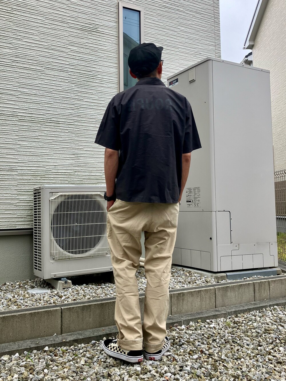 ブラック系のシャツ/ブラウス、ベージュ系のチノパンツ、その他のスニーカーを着用したメンズの春コーディネートの2枚目の写真