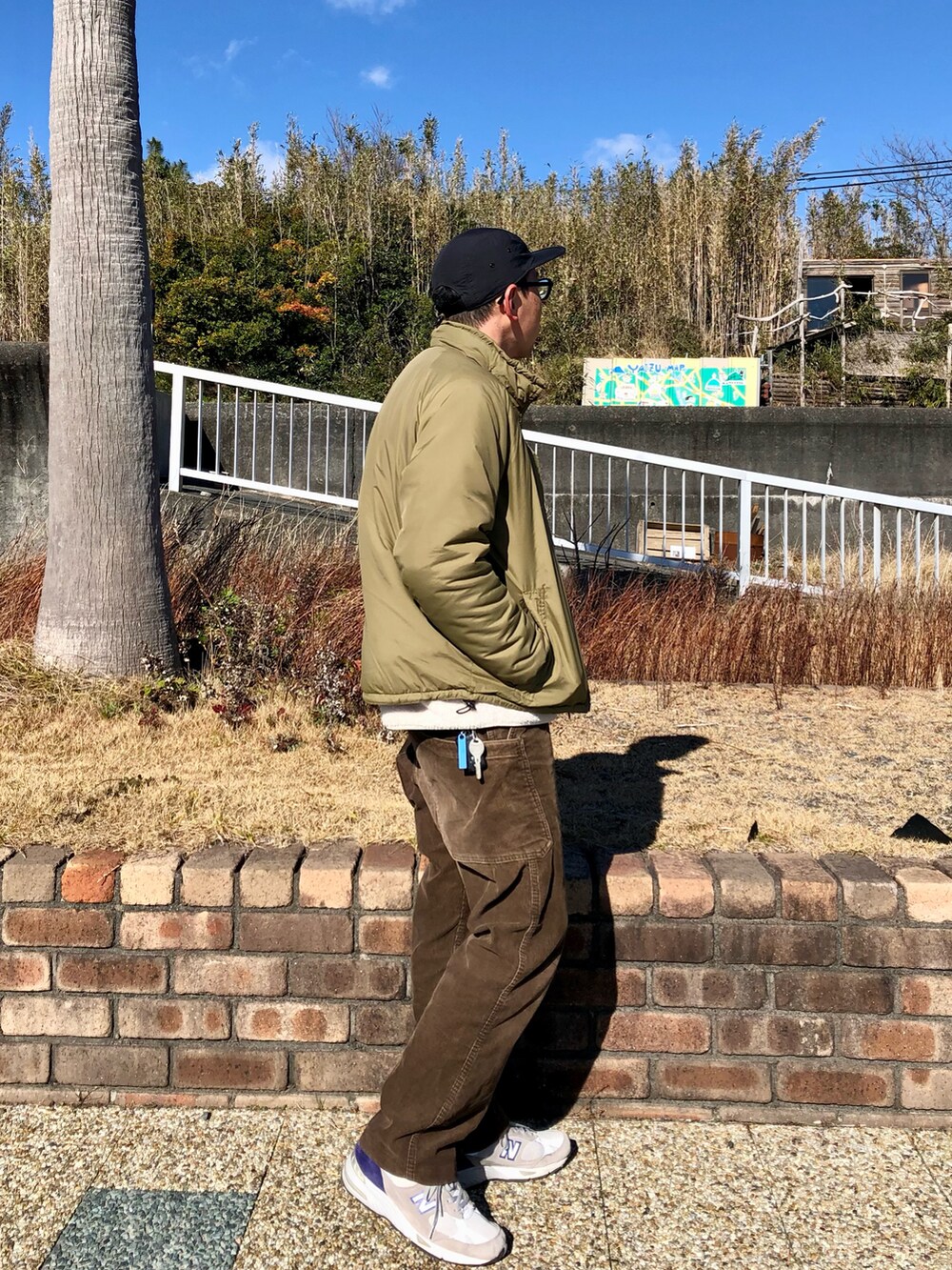 ホワイト系のTシャツ/カットソー、グリーン系のミリタリージャケット、ブラウン系のパンツを着用したメンズの冬コーディネートの4枚目の写真