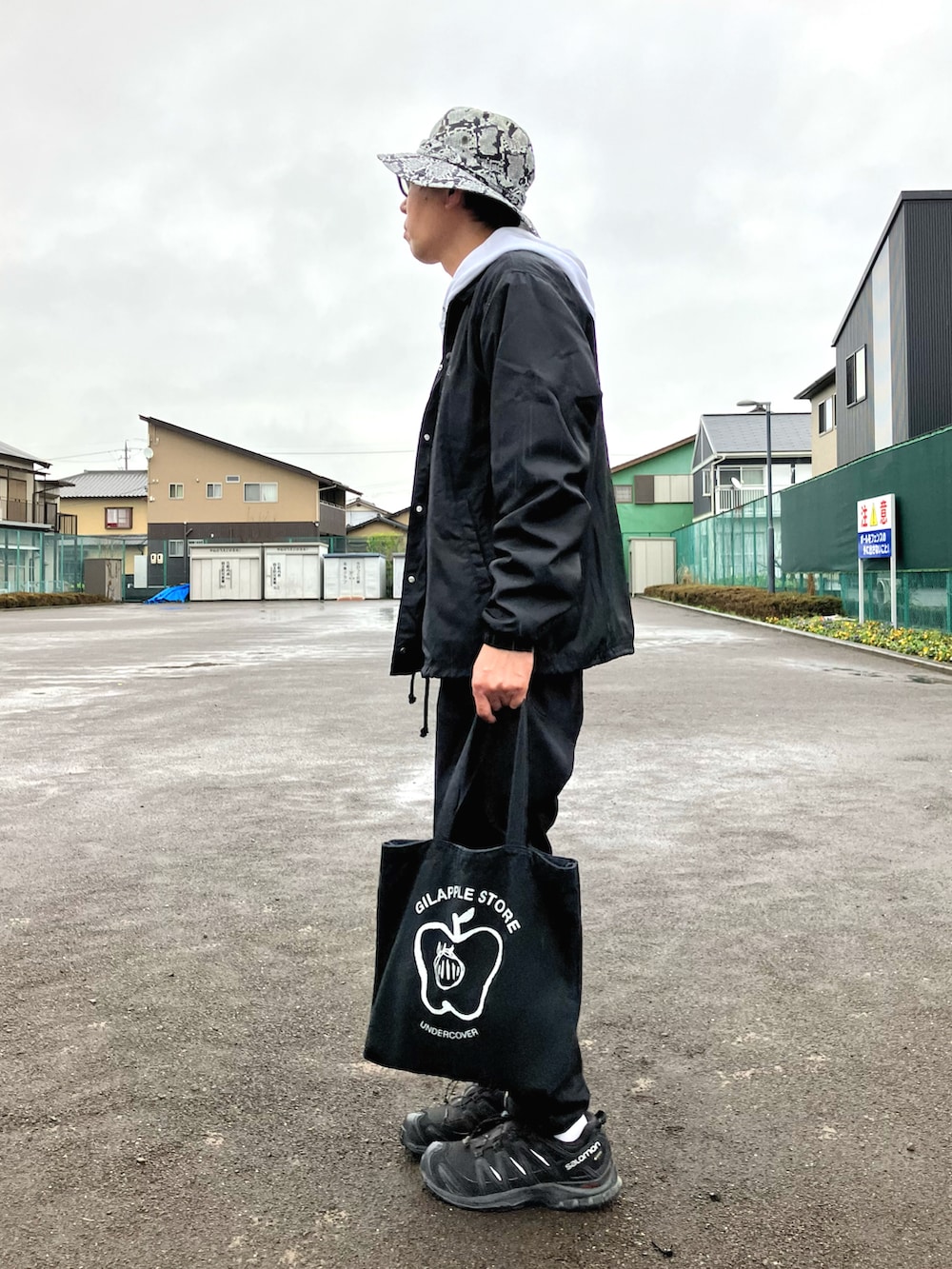 ホワイト系のパーカー、ブラック系のブルゾン、ブラック系のエコバッグ/サブバッグを着用したメンズの春コーディネートの2枚目の写真