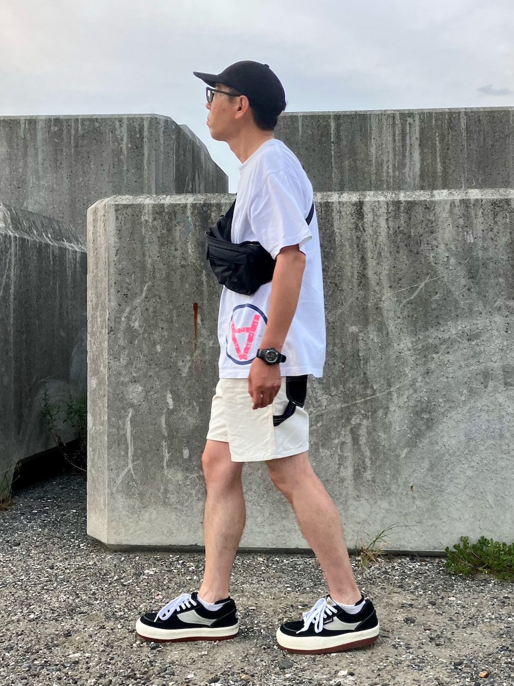 ブラック系のスニーカー、ホワイト系のTシャツ/カットソー、ホワイト系のその他パンツを着用したメンズの秋コーディネートの2枚目の写真