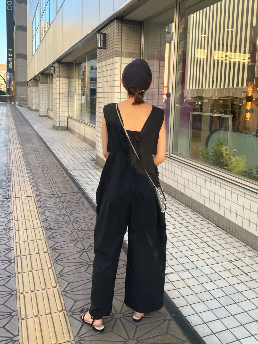 ブラック系のサンダル、ブラック系のつなぎ/オールインワン、シルバー系のスマホケース/カバーを着用したレディースの夏コーディネートの2枚目の写真