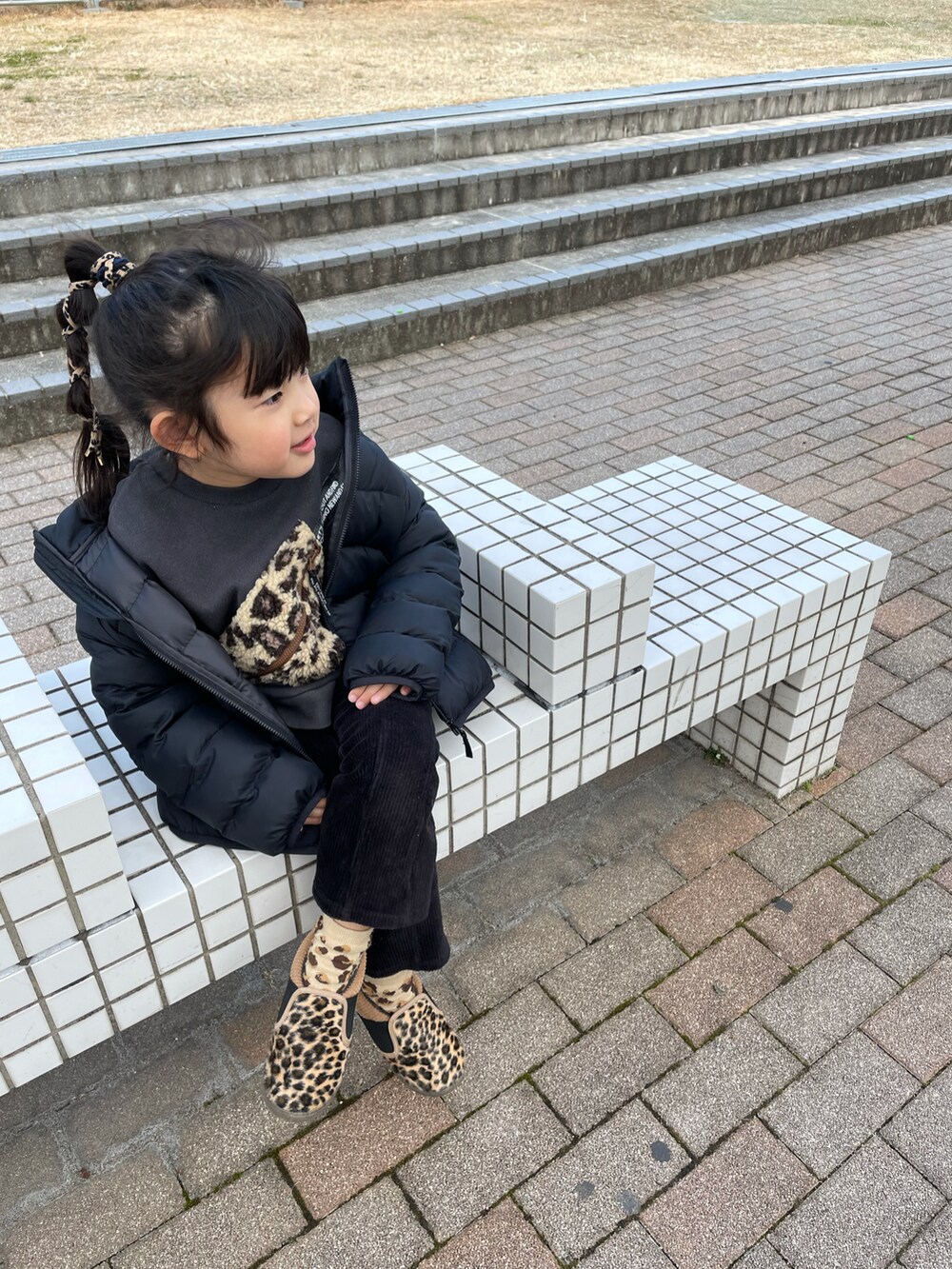 グレー系のスウェット、ブラック系のその他パンツ、ベージュ系のシューズを着用したキッズの冬コーディネートの2枚目の写真