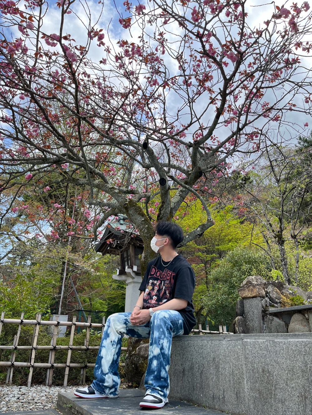 ブラック系のTシャツ/カットソー、ブルー系のデニムパンツ、レッド系のスニーカーを着用したメンズの春コーディネートの2枚目の写真