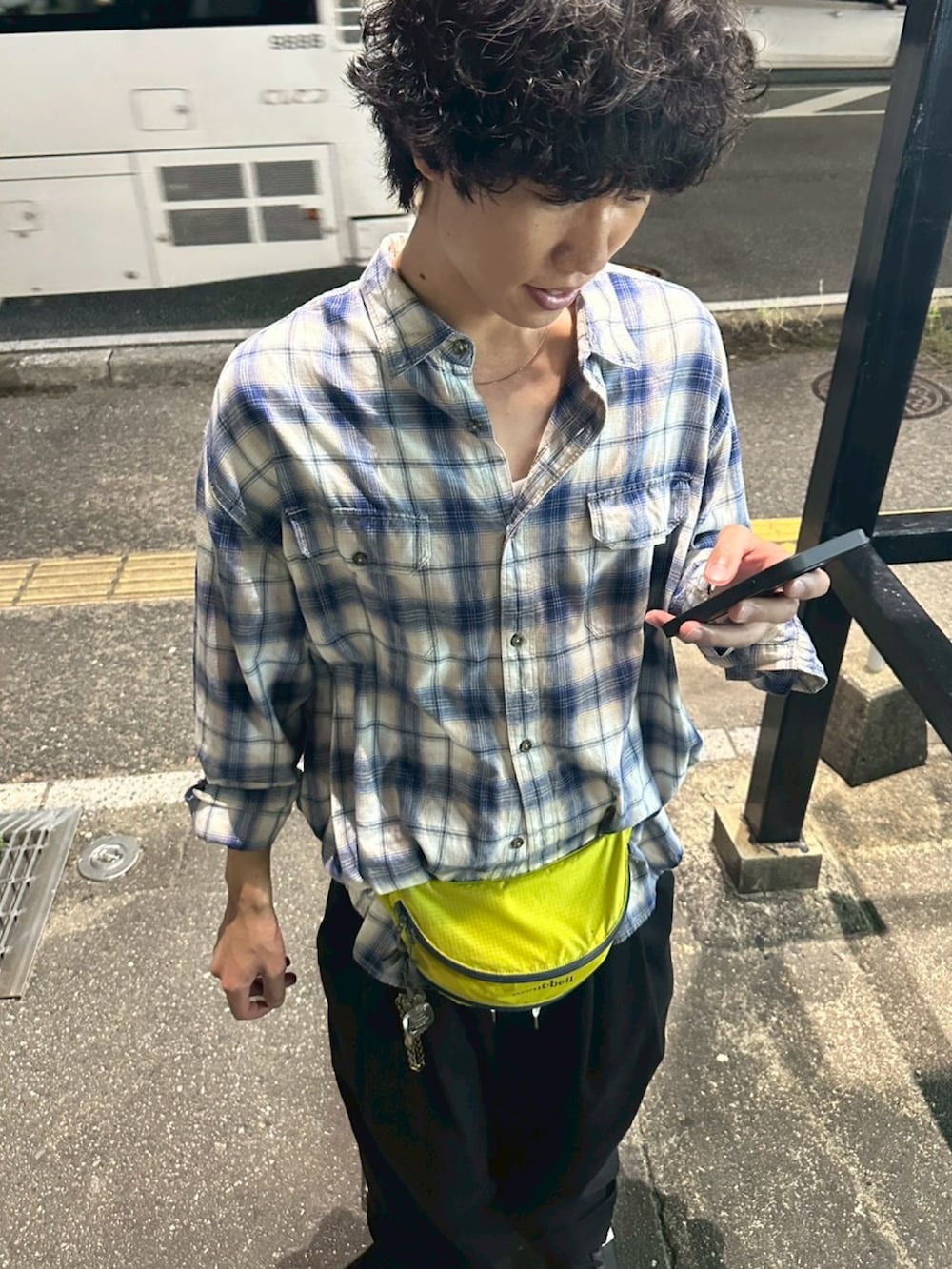 ブルー系のシャツ/ブラウス、イエロー系のボディバッグ/ウエストポーチ、ブラック系のスニーカーを着用したメンズの秋コーディネートの2枚目の写真