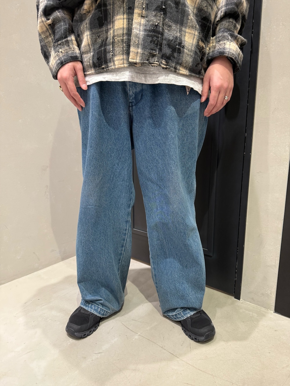 ブルー系のデニムパンツ、ブラック系のスニーカー、ブラック系のショルダーバッグを着用したメンズの秋コーディネートの5枚目の写真