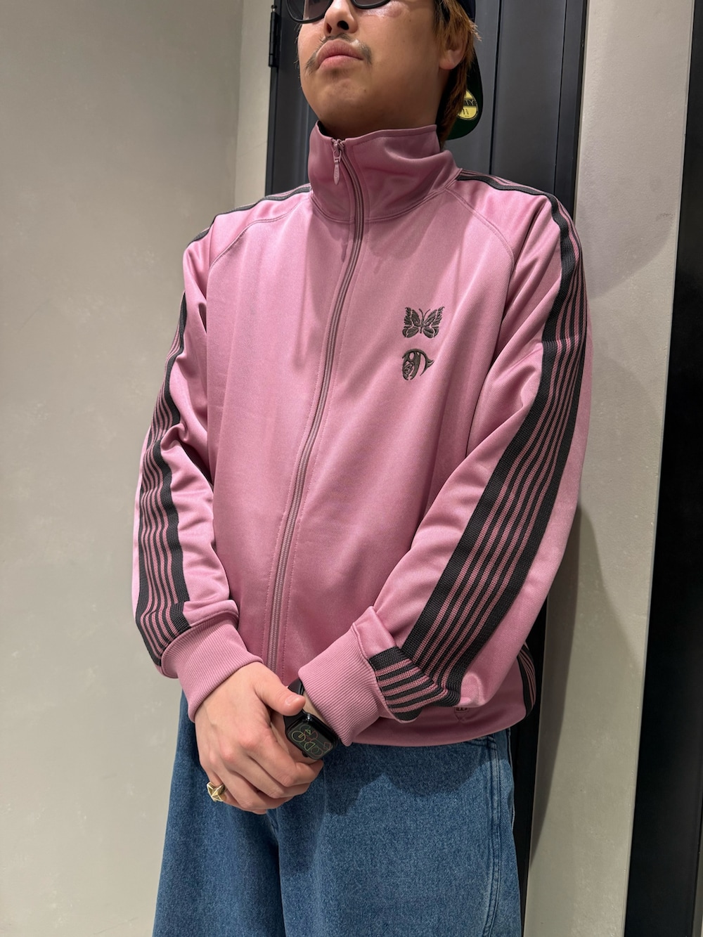 ブラック系のスニーカー、ブルー系のデニムパンツを着用したメンズの春コーディネートの2枚目の写真