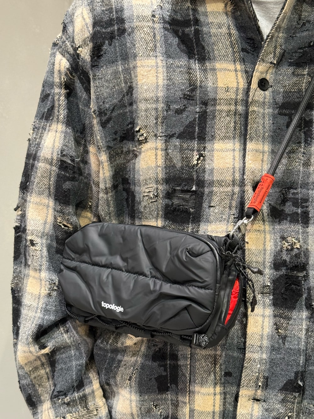 ブルー系のデニムパンツ、ブラック系のスニーカー、ブラック系のショルダーバッグを着用したメンズの秋コーディネートの4枚目の写真