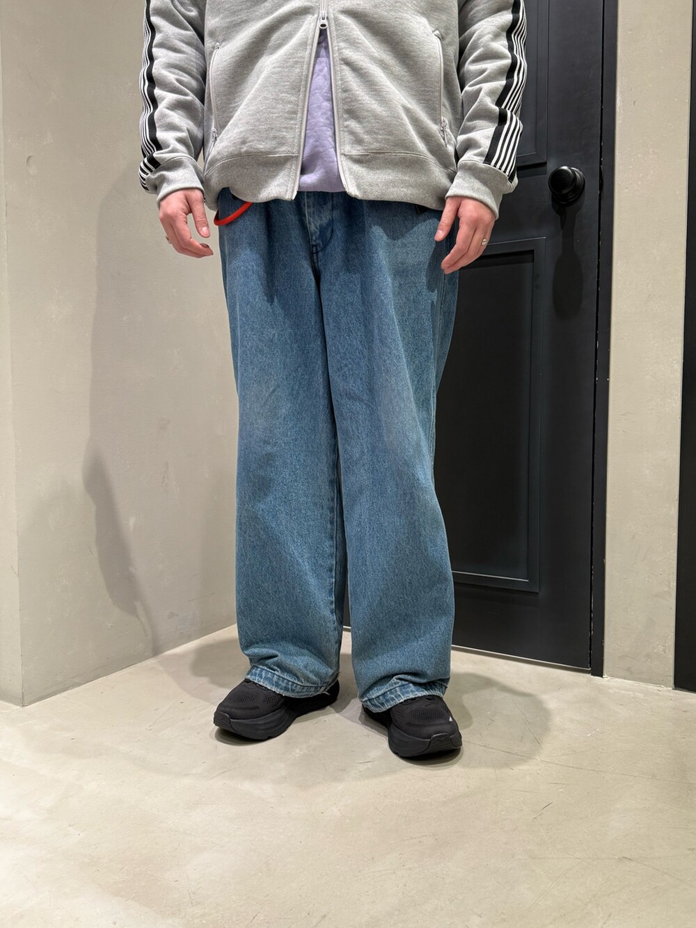 ブラック系のスニーカー、ブルー系のデニムパンツを着用したメンズの冬コーディネートの3枚目の写真