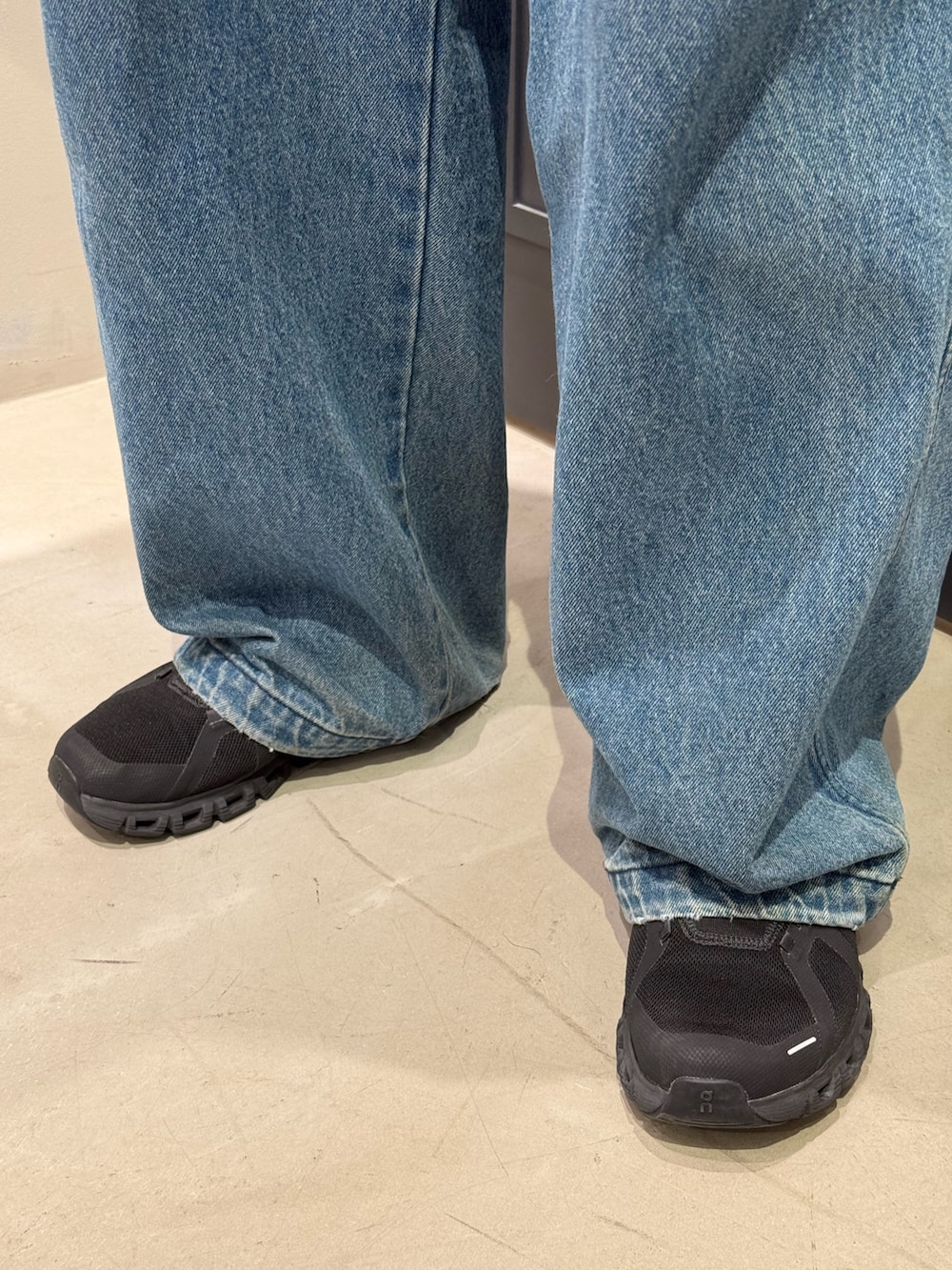 ブルー系のカーディガン/ボレロ、ブルー系のデニムパンツ、ブラック系のスニーカーを着用したメンズの秋コーディネートの6枚目の写真