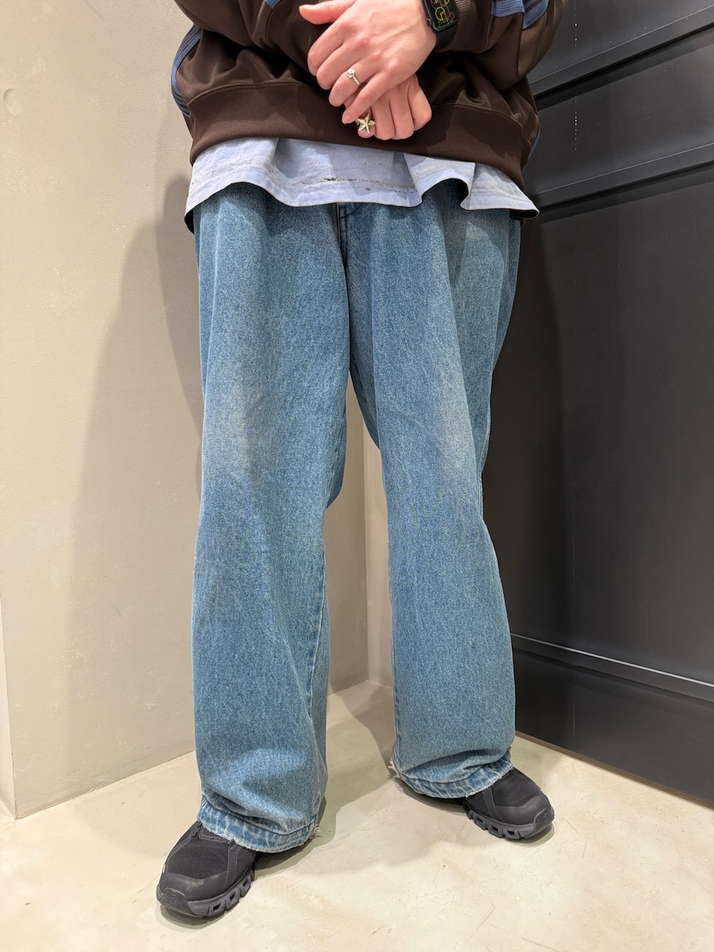 ブルー系のデニムパンツ、ブラック系のスニーカーを着用したメンズの春コーディネートの3枚目の写真