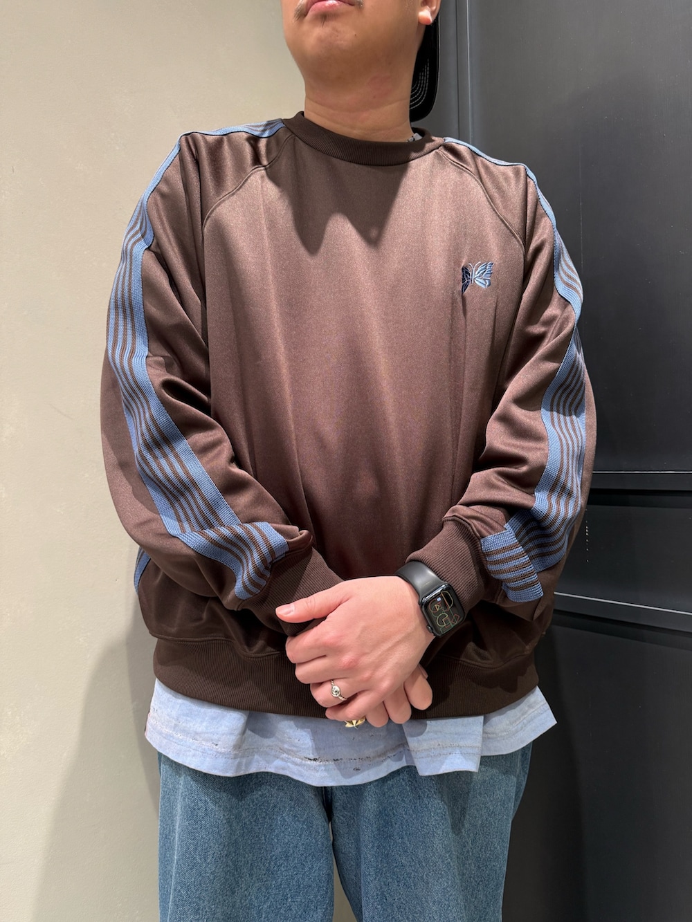 ブルー系のデニムパンツ、ブラック系のスニーカーを着用したメンズの春コーディネートの2枚目の写真