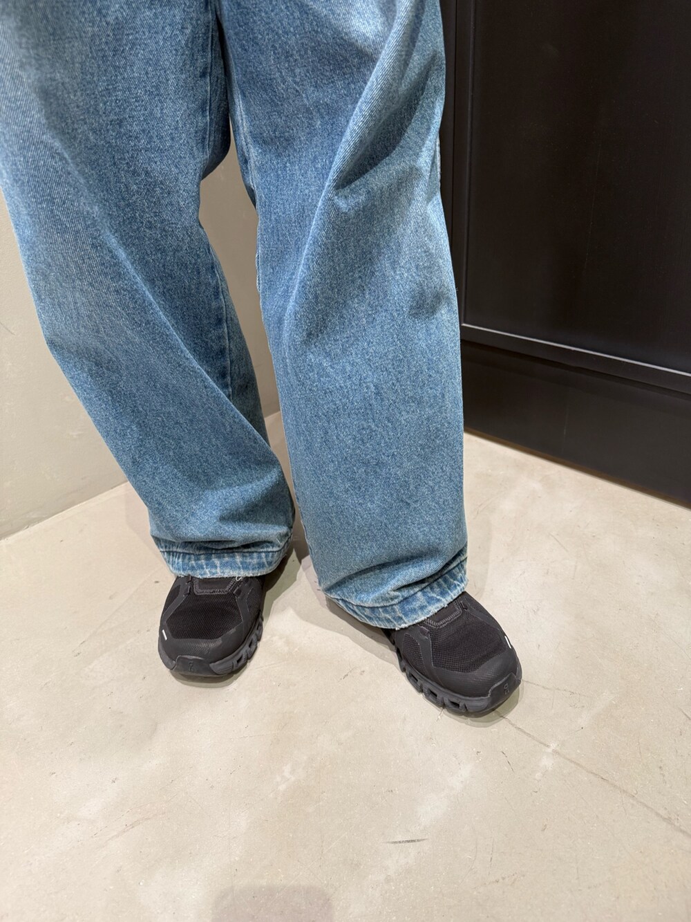 ブルー系のデニムパンツ、ブラック系のスニーカーを着用したメンズの春コーディネートの4枚目の写真