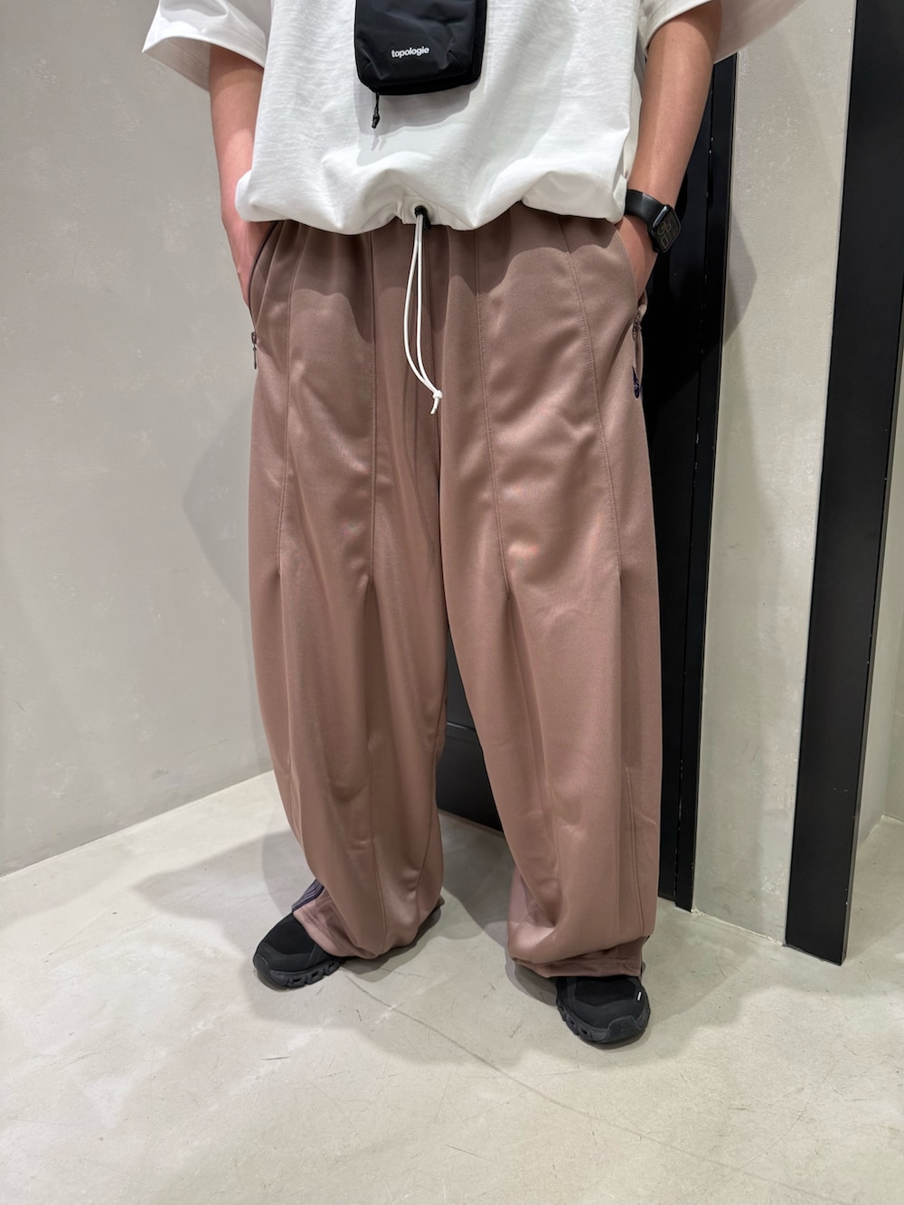 ブラック系のショルダーバッグ、ブラック系のスニーカー、ホワイト系のTシャツ/カットソーを着用したメンズの春コーディネートの3枚目の写真