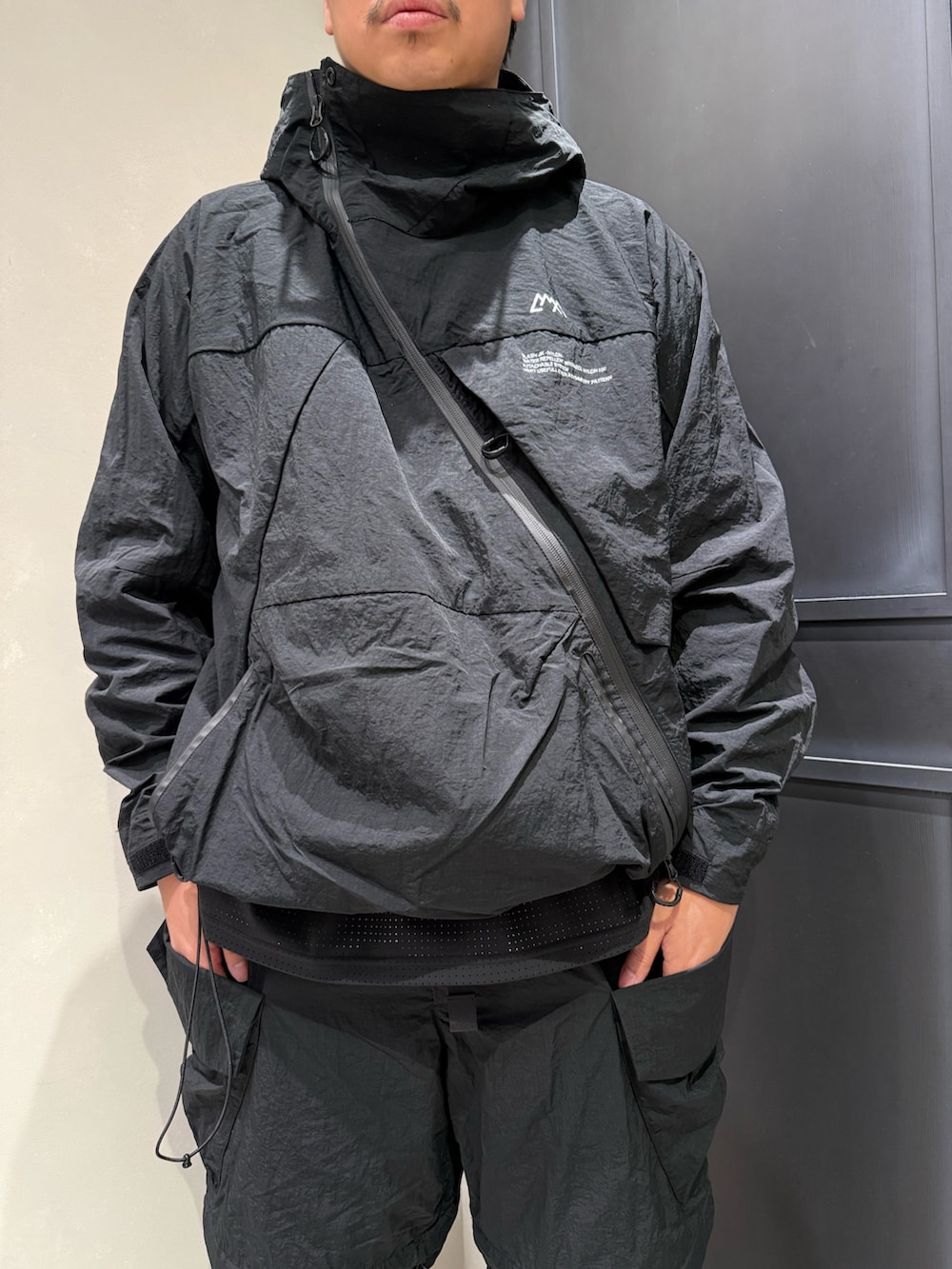 ブラック系のマウンテンパーカー、ブラック系のカーゴパンツを着用したメンズの秋コーディネートの2枚目の写真