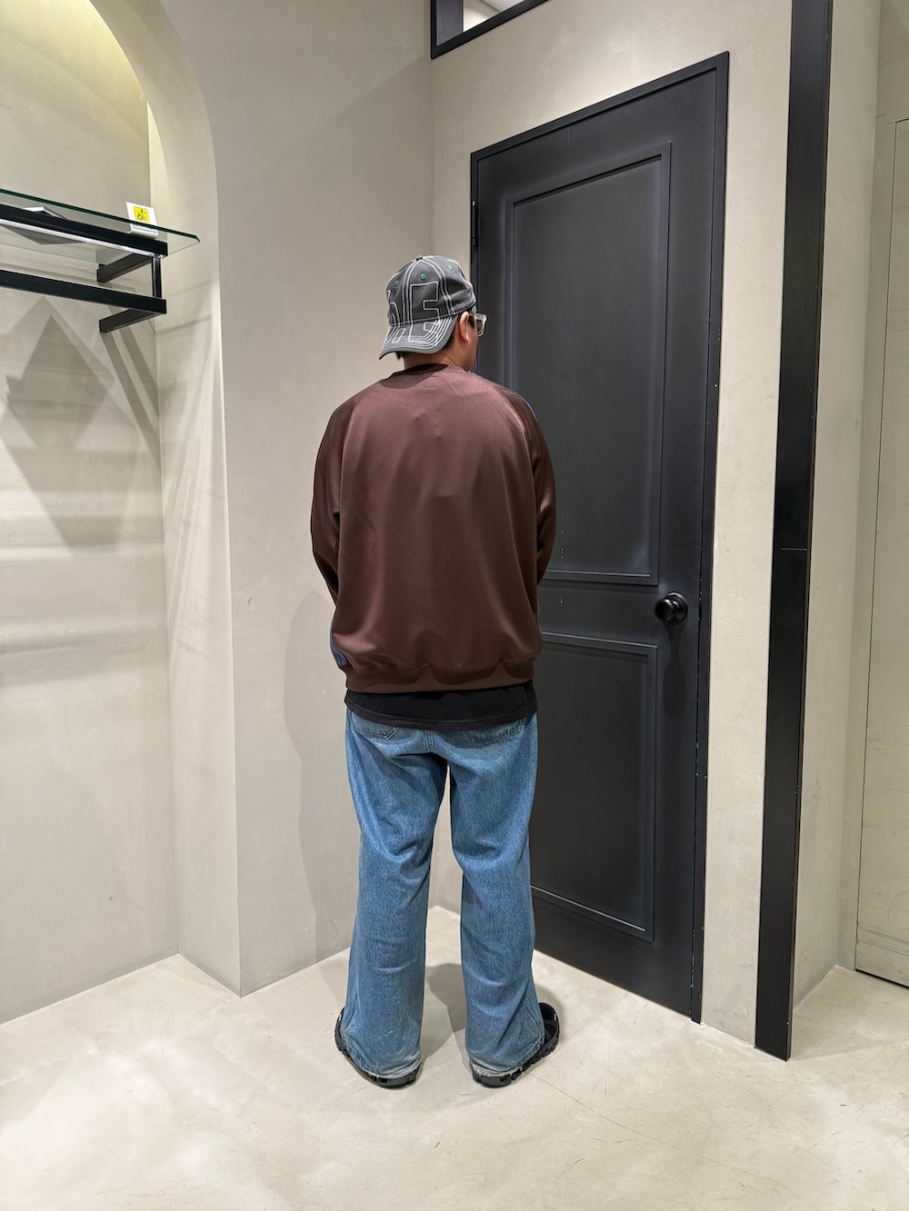 ブルー系のデニムパンツ、ブラック系のスニーカーを着用したメンズの春コーディネートの5枚目の写真