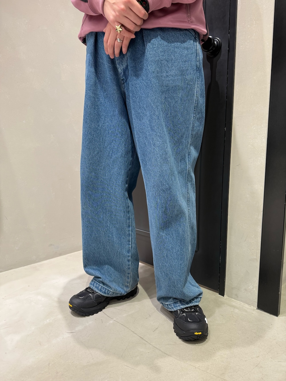 ブラック系のスニーカー、ブルー系のデニムパンツを着用したメンズの春コーディネートの3枚目の写真