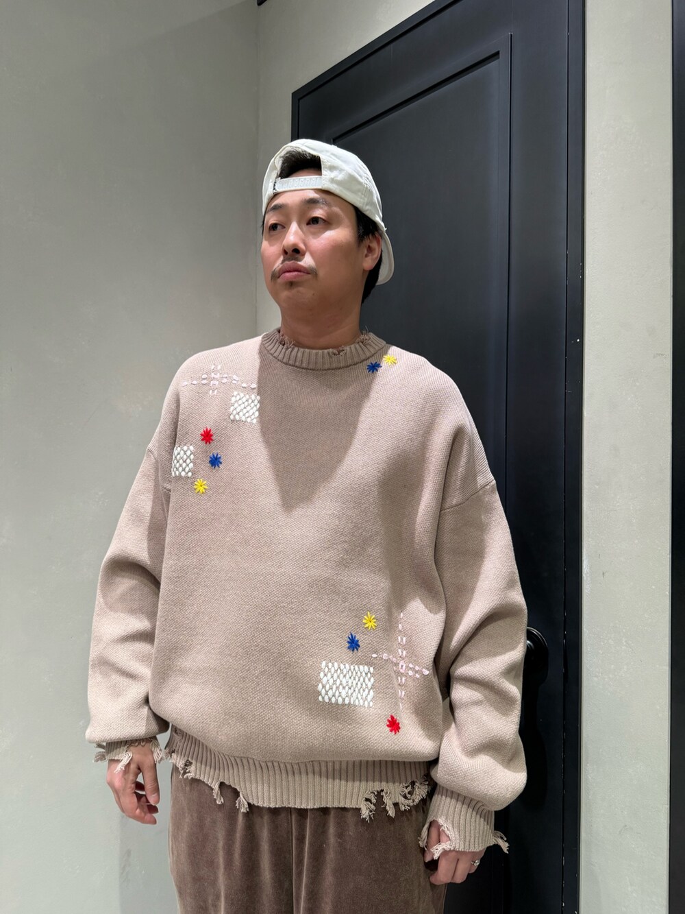 ベージュ系のニット/セーター、ベージュ系のサンダルを着用したメンズの秋コーディネートの6枚目の写真