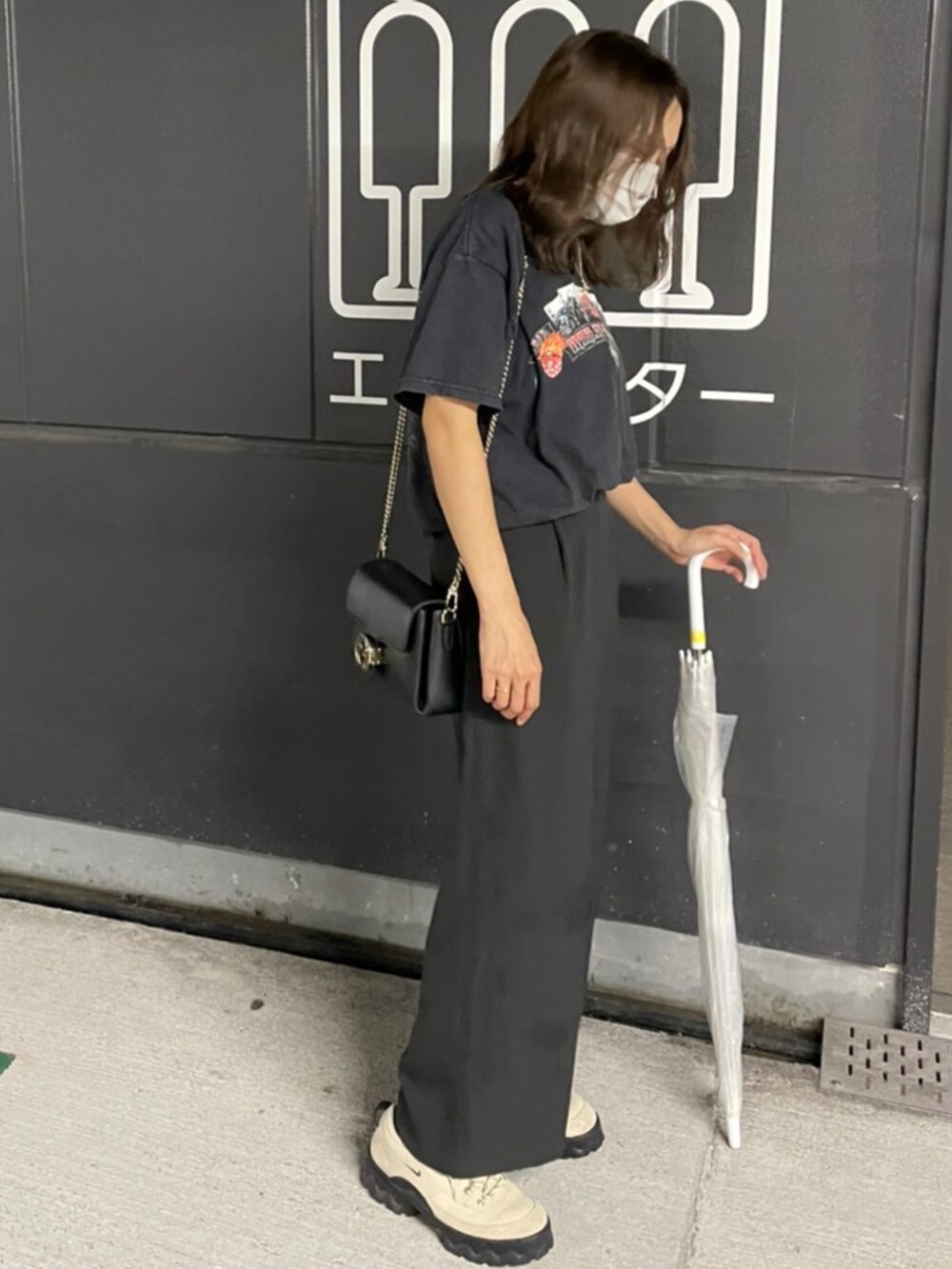 ブラック系のTシャツ/カットソー、グリーン系のスニーカーを着用したレディースの秋コーディネートの2枚目の写真