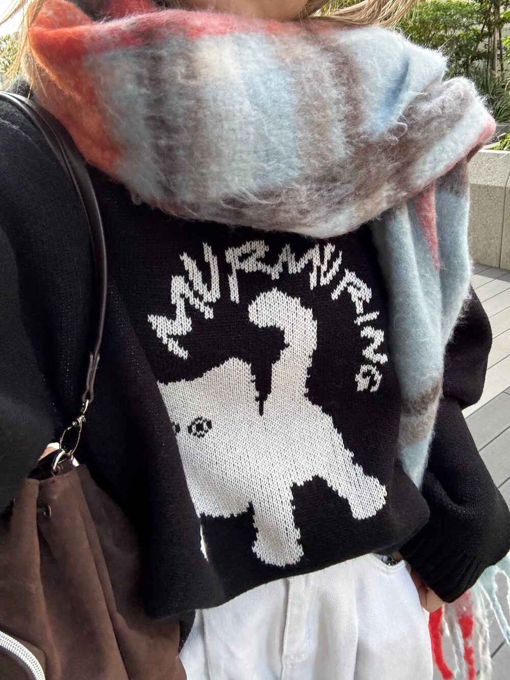 ブラウン系のショルダーバッグ、ブラック系のニット/セーター、ブルー系のマフラーを着用したレディースの秋コーディネートの7枚目の写真