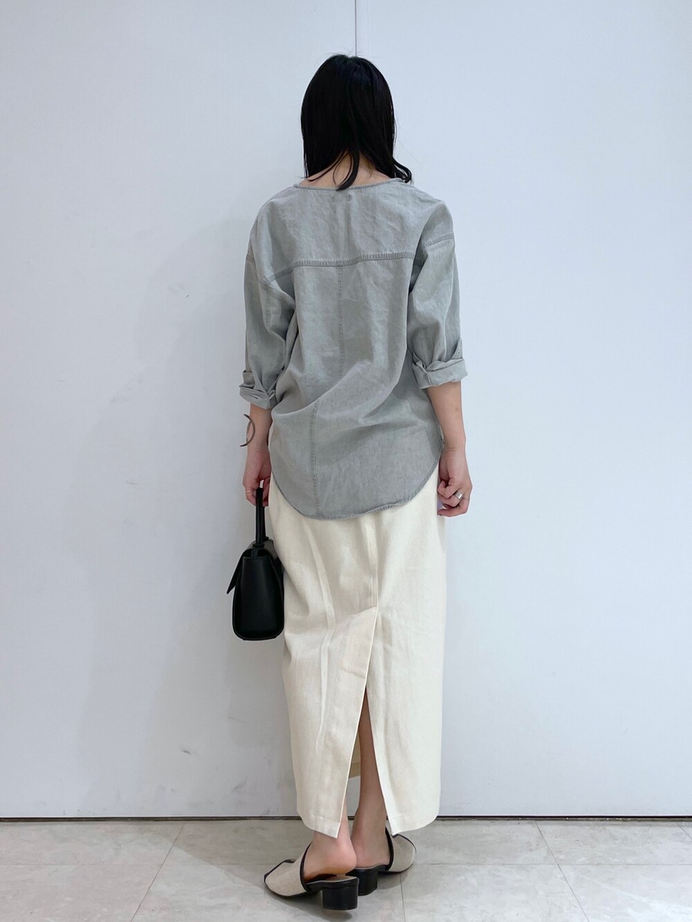 グレー系のシャツ/ブラウス、ホワイト系のスカート、ブラック系のサンダルを着用したレディースの春コーディネートの3枚目の写真