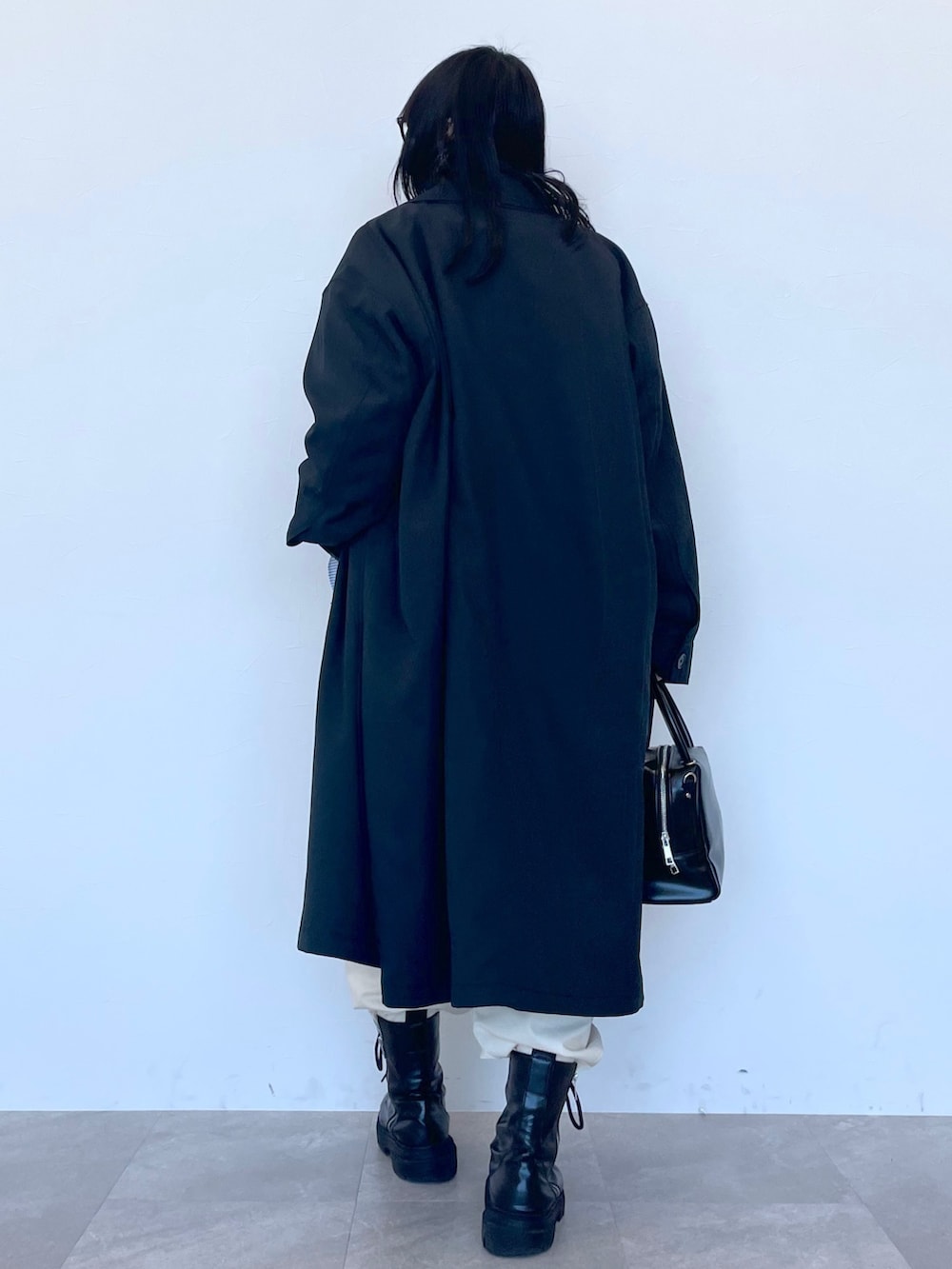 ブラック系のステンカラーコート、ベージュ系のニット/セーター、ブルー系のシャツ/ブラウスを着用したレディースの冬コーディネートの4枚目の写真