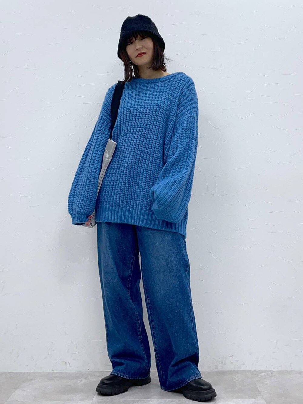 ブラック系のブーツ、ブルー系のデニムパンツ、シルバー系のトートバッグを着用したレディースの秋コーディネートの8枚目の写真