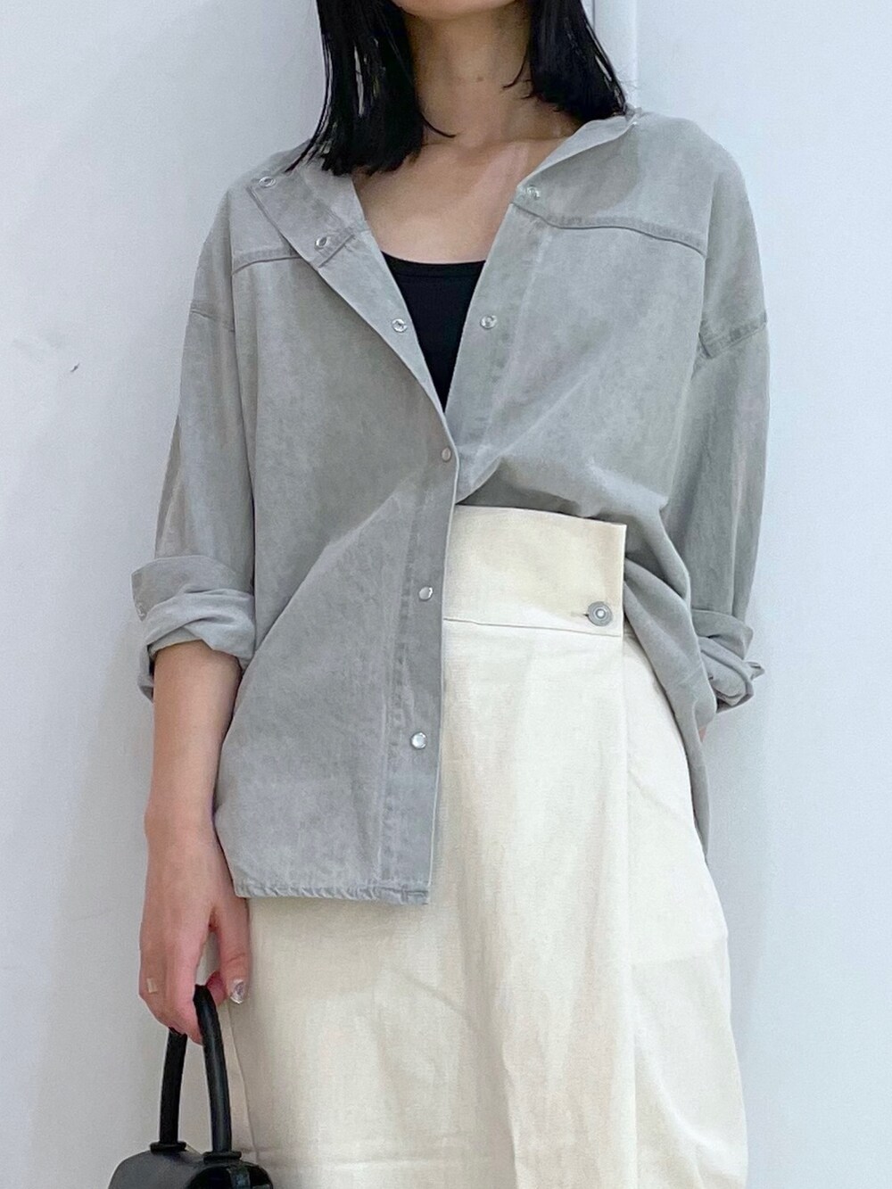 グレー系のシャツ/ブラウス、ホワイト系のスカート、ブラック系のサンダルを着用したレディースの春コーディネートの4枚目の写真