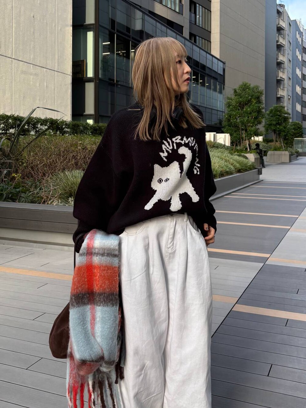 ブラウン系のショルダーバッグ、ブラック系のニット/セーター、ブルー系のマフラーを着用したレディースの秋コーディネートの5枚目の写真