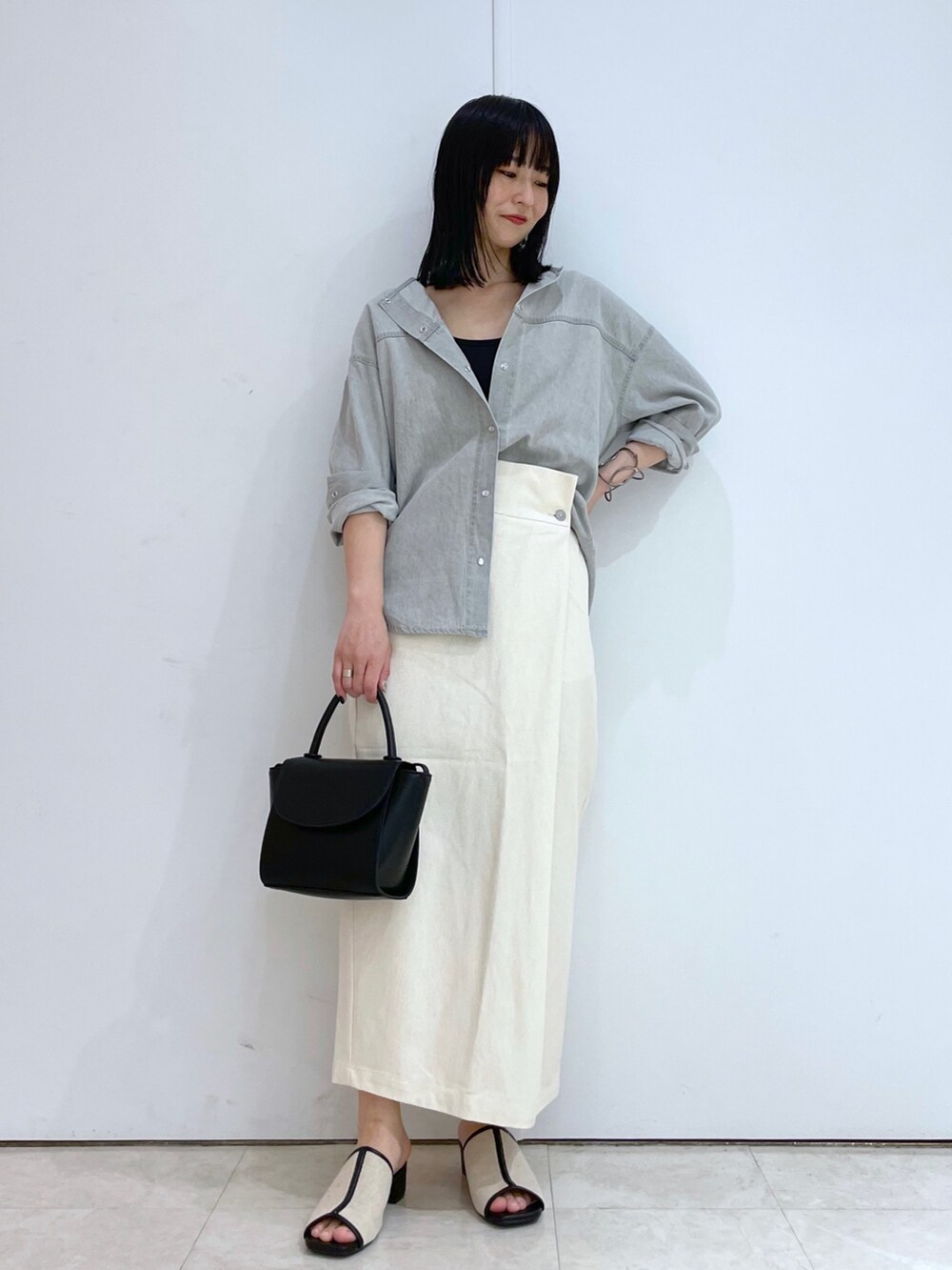 グレー系のシャツ/ブラウス、ホワイト系のスカート、ブラック系のサンダルを着用したレディースの春コーディネートの5枚目の写真