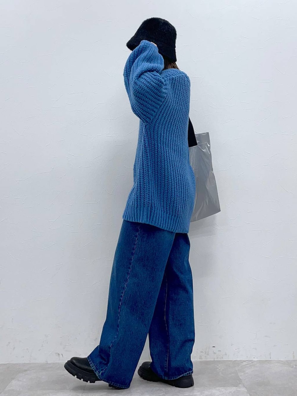 ブラック系のブーツ、ブルー系のデニムパンツ、シルバー系のトートバッグを着用したレディースの秋コーディネートの2枚目の写真