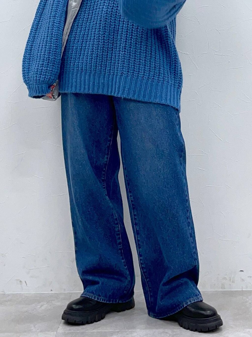 ブラック系のブーツ、ブルー系のデニムパンツ、シルバー系のトートバッグを着用したレディースの秋コーディネートの7枚目の写真