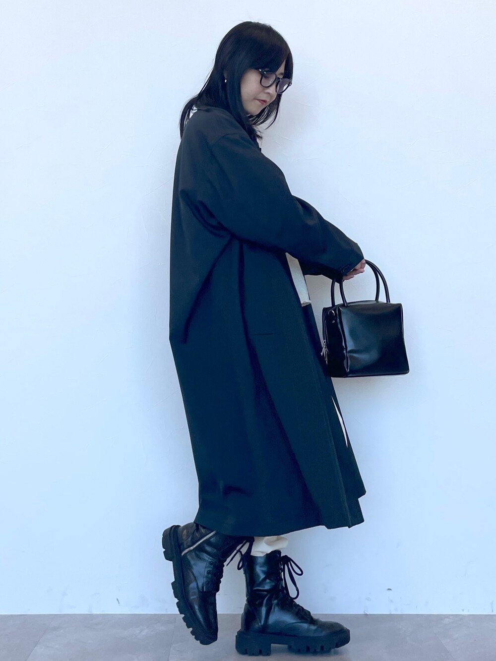 ブラック系のステンカラーコート、ベージュ系のニット/セーター、ブルー系のシャツ/ブラウスを着用したレディースの冬コーディネートの5枚目の写真