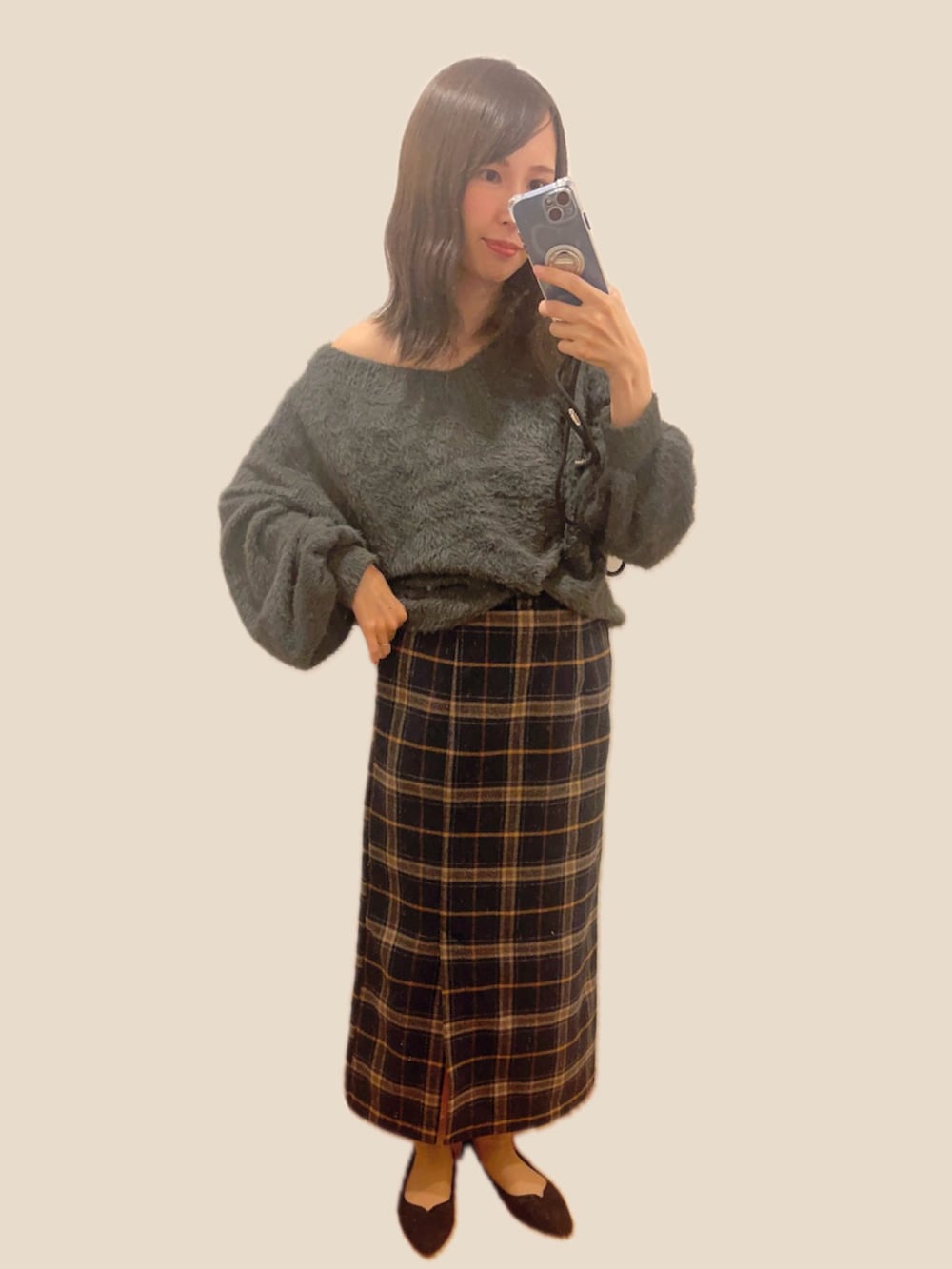 グレー系のニット/セーター、ブラウン系のスカート、ブラック系のパンプスを着用したレディースの冬コーディネートの2枚目の写真