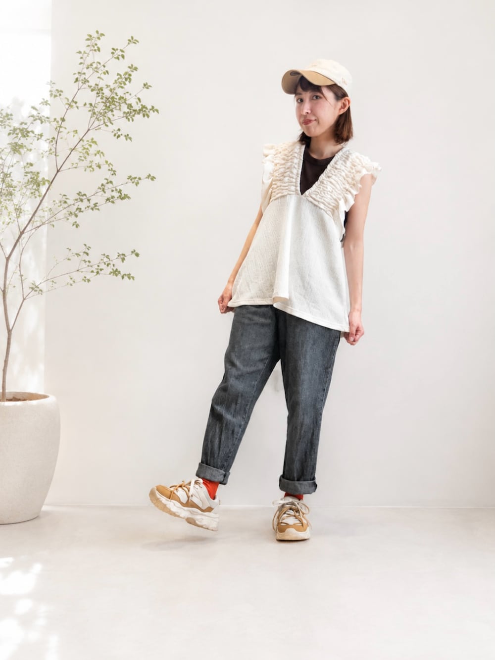 ブラック系のデニムパンツ、ベージュ系のスニーカー、ホワイト系のシャツ/ブラウスを着用したレディースの夏コーディネートの2枚目の写真